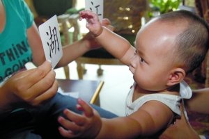 昨日，女寶寶在家中通過選擇卡片回答媽媽提出的問題。本報記者 吳江 攝